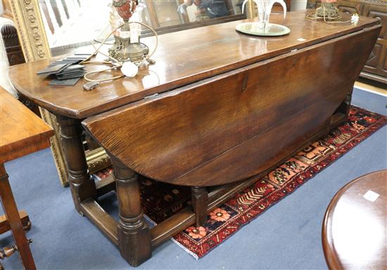 A 17th century style oak wake table on turned legs with peripheral stretcher, W.240cm